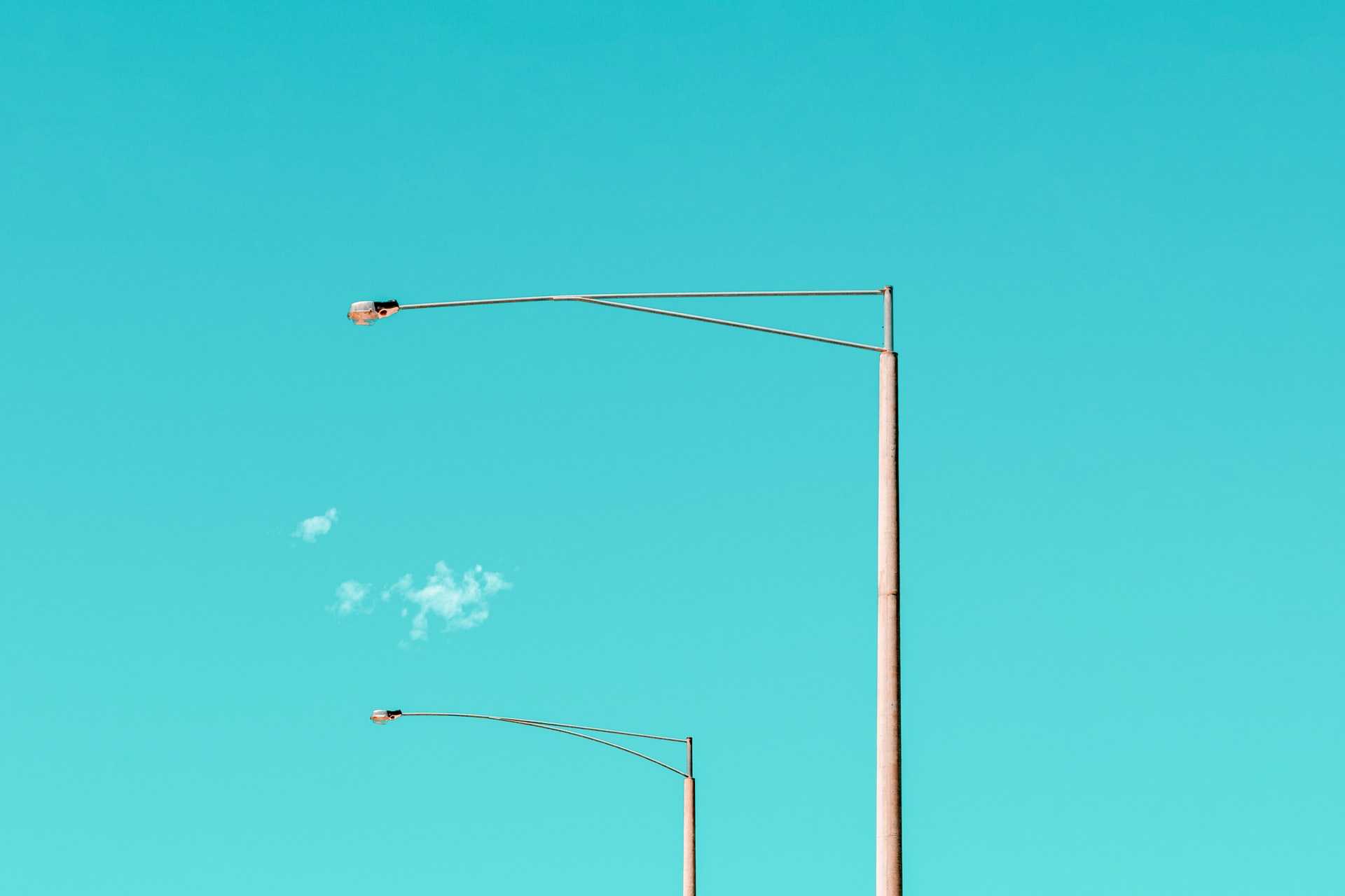 A row of futuristic streetlights set against a dusk sky.