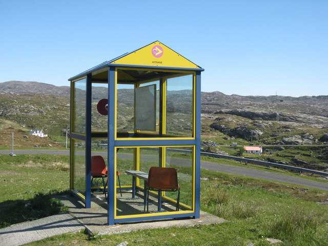 A bus shelter located on a rural road.