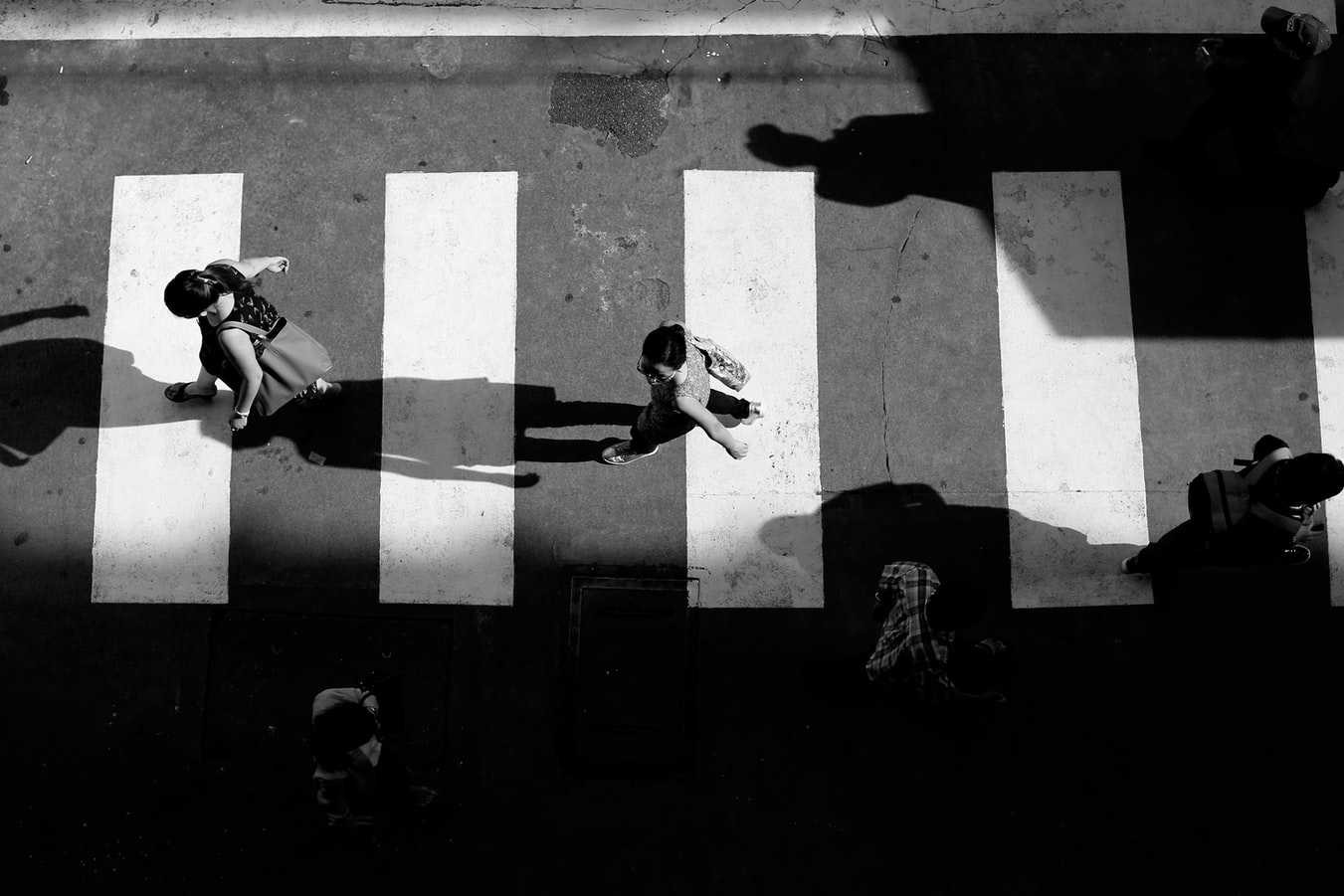 Black and white overhead shot of people in a crosswalk.