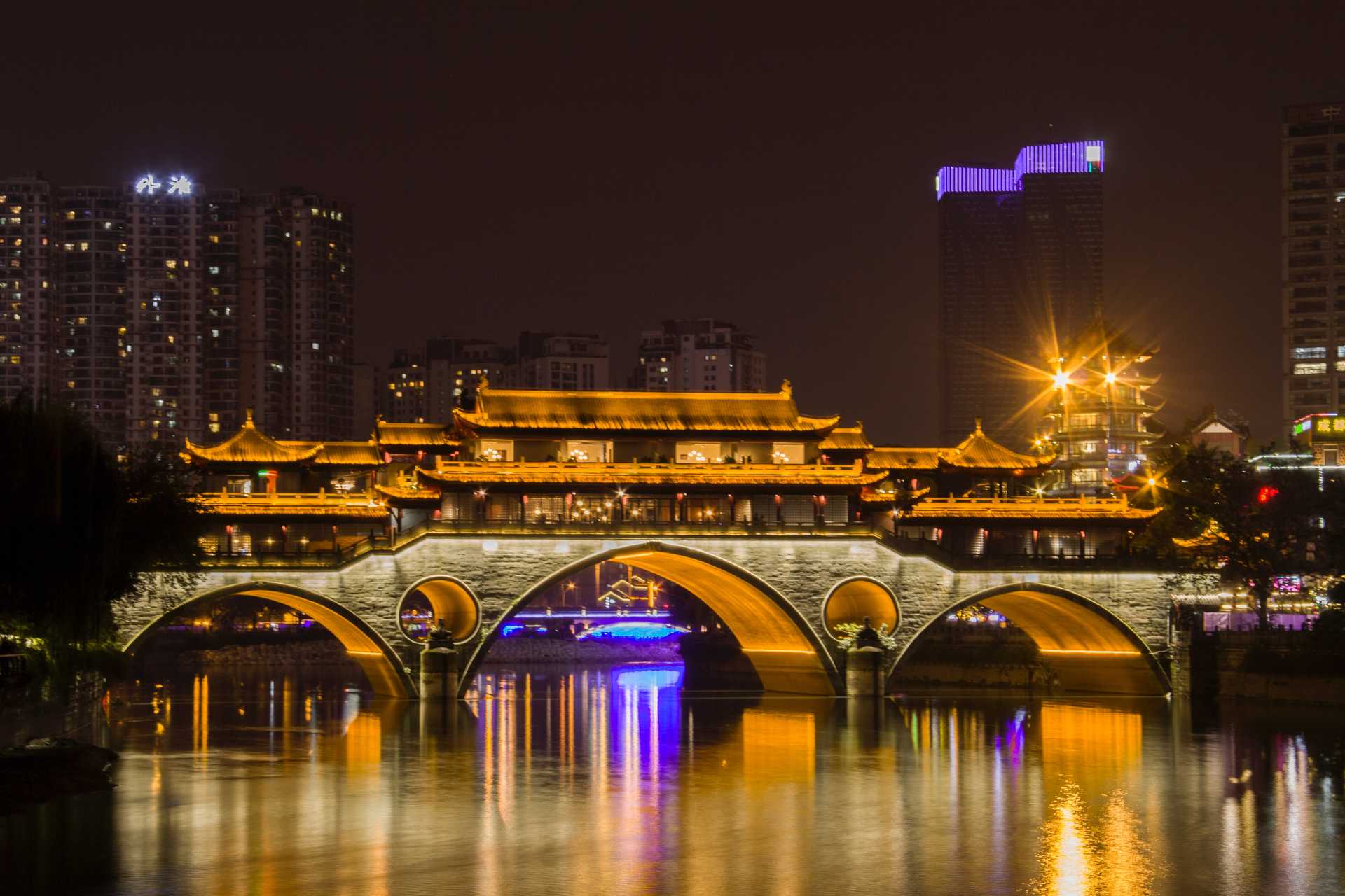 Night view of an illuminated historical bridge in Chengdu.