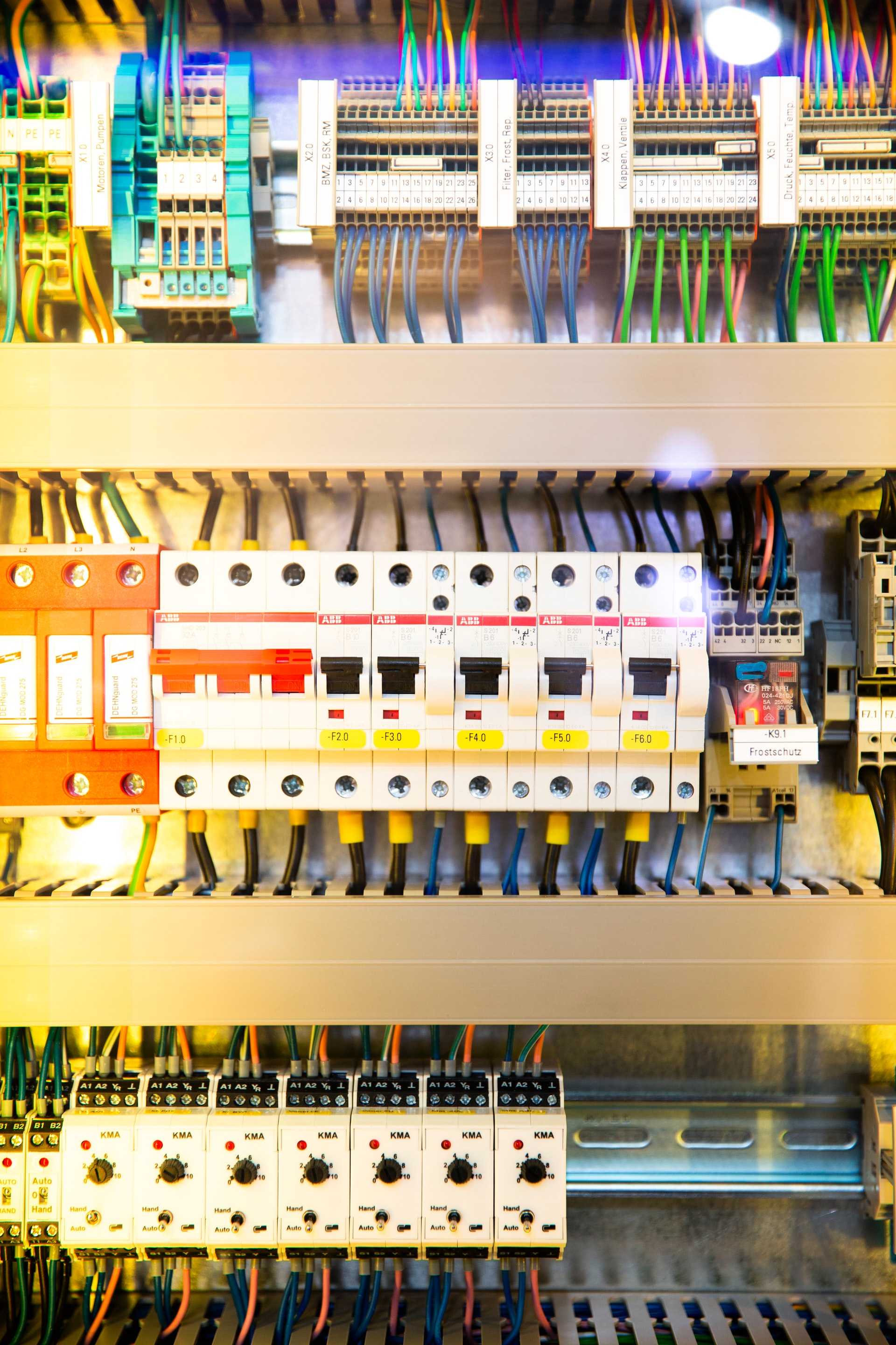A circuit breaker panel with multi-colored switches and labels.