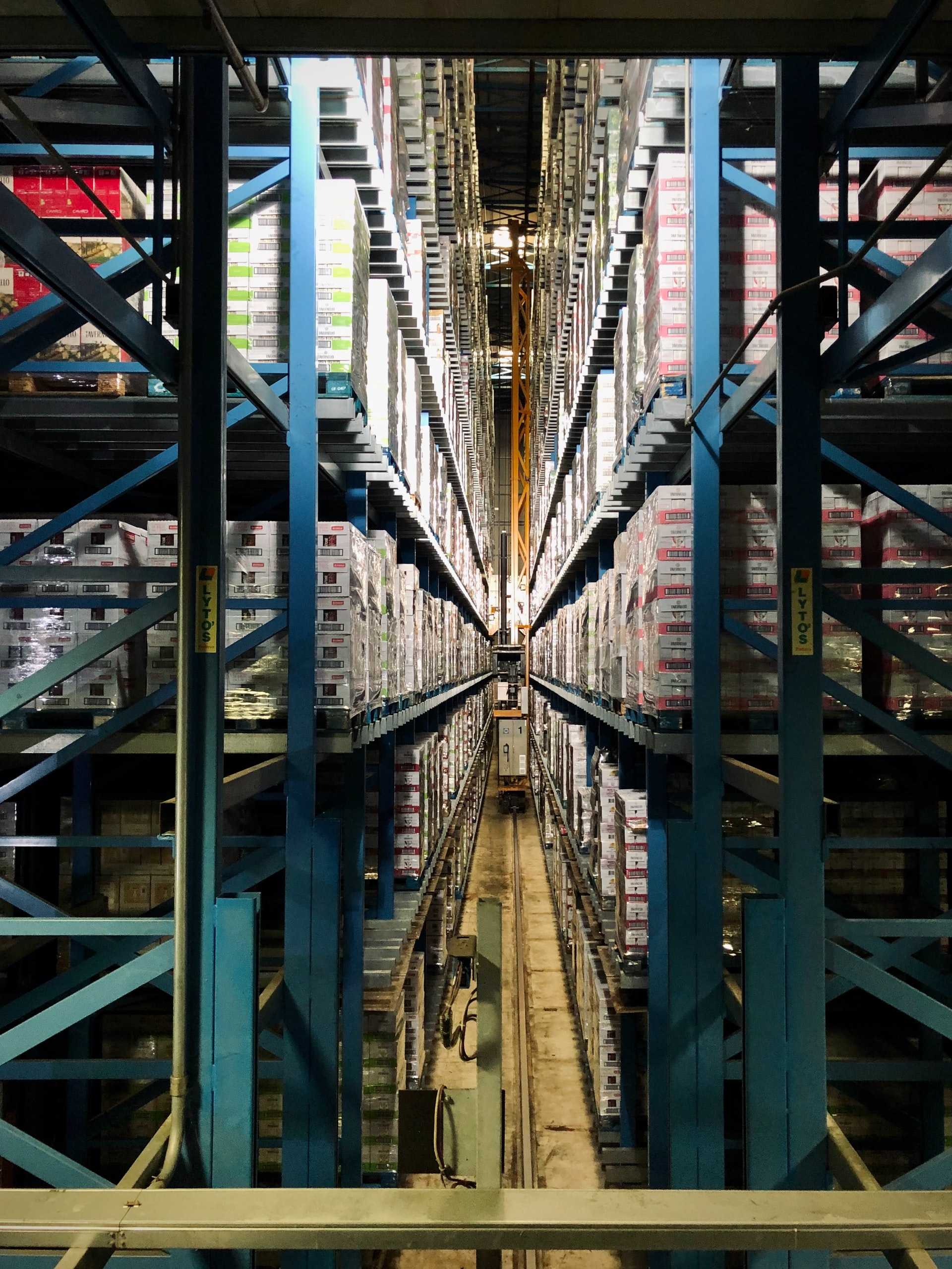 Goods are stacked high on shelves in a warehouse.